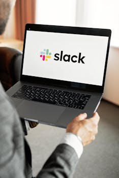 A businessman uses Slack on a laptop, showcasing modern communication technology.