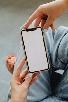 A close-up image of hands holding a smartphone with a blank screen, perfect for app demonstration.