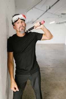 Adult man with VR headset posing with nunchaku in an indoor setting.