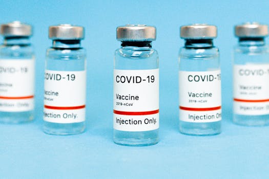 Close-up of COVID-19 vaccine vials labeled for injection on a blue background.